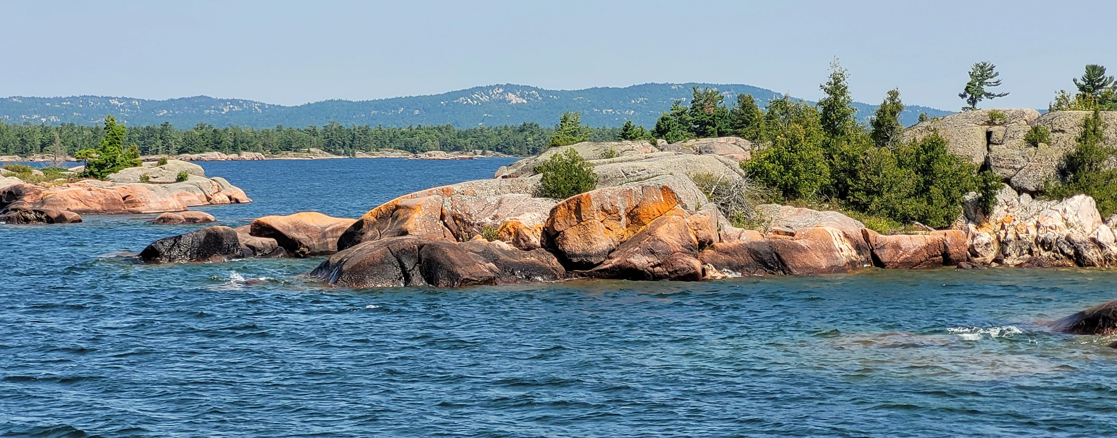 View from Benjamin Island of an island chain leading to it from Fox Island with the La Cloche mountains in the distance, in Lake Huron, Ontario, Canada